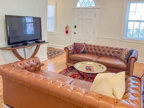 Cozy living room with historic charm. TV equipped with Apple TV and Roku for guests to stream their favorite shows.