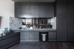 A contemporary, fully-equipped kitchen has a gas stove, oven, full-sized fridge, microwave, dishwasher and coffee maker, as well as all the necessary cooking utensils