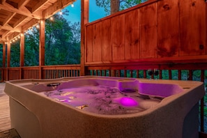 Experience this cabin’s luxurious hot tub with soothing purple lights—your private haven for relaxation and serenity.