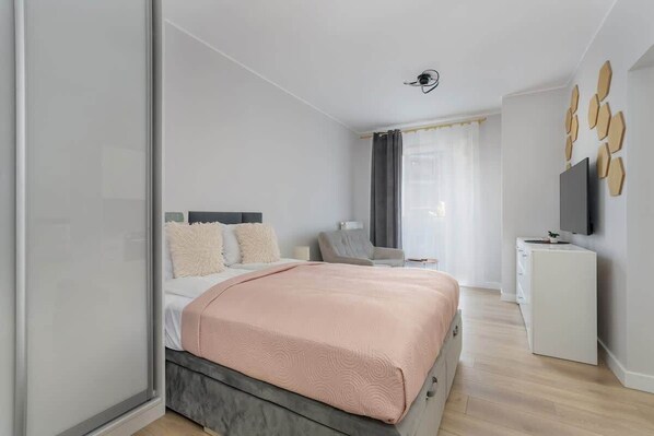 A comfortable double bed and a capacious closet with a mirror.