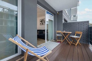 A balcony with deck chairs and a small wooden table, ideal for relaxation.
