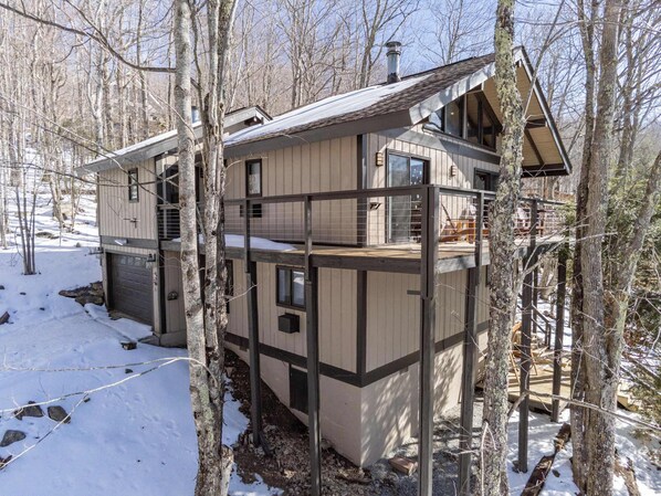 Charming mountain cabin nestled in a snowy forest, offering a tranquil escape with stunning winter views and inviting outdoor spaces.