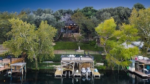 Our vacation home, nestled amid lush greenery, complemented by a private boat dock with seating on the top deck.