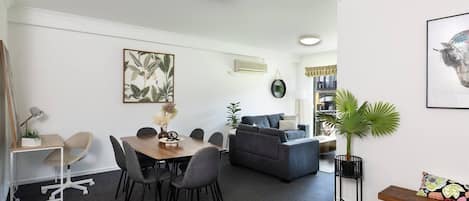 This inviting space combines a dining table for six, a cozy sofa lounge, and a designated desk for productivity.