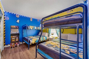 Delight your little ones with this vibrant Minion-themed bedroom, complete with bunk beds and an arcade game.