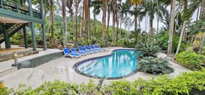 The inground pool is surrounded by lush tropical scenery