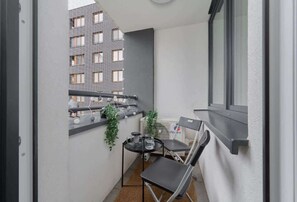 A balcony with outdoor seating and views of the city’s modern architecture.
