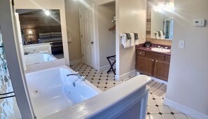 Jacuzzi for 2, vanity, with a large walk-in shower, and water closet down the corridor.