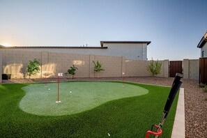 “Transform your backyard into a golfer’s paradise! 🌳🏌️‍♂️ Perfect your putt under the serene sky, surrounded by nature’s beauty. Whether it’s sunrise or sunset, every swing here counts. ⛳️✨ #GolfLife #BackyardOasis #PuttingGreen”