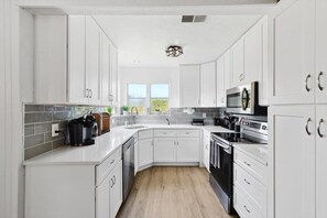 With a functional and space efficient layout, this kitchen has everything you need to unleash your culinary creativity – including a coffee machine!