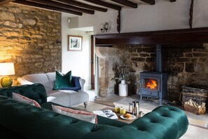 Beautiful sitting room with exposed beams and stonework and a wood burning stove