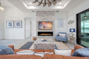 The Living Room Features a Fire Place, Smart TV and Comfortable Seating