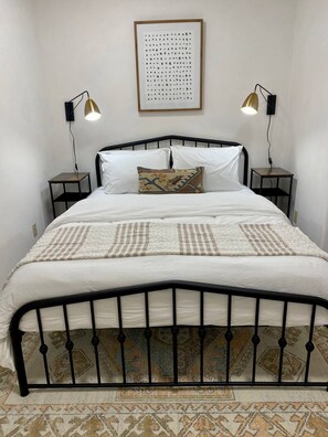 Queen size bed topped with cozy bedding