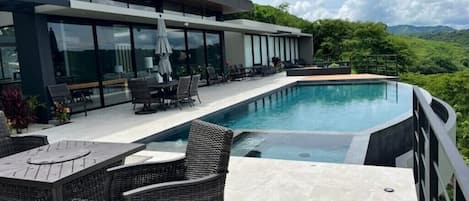 Enjoy this gorgeous infinity pool with plenty of seating & lounge chairs