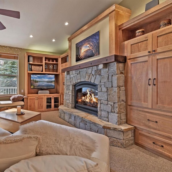 Spacious living room with beautiful fireplace, comfortable couch, luxurious throw blankets and a great view of KT-22!