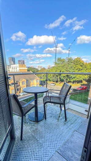 Sunny balcony with a charming seating area, providing a relaxing spot to enjoy panoramic views of Shoreditch and its vibrant surroundings.