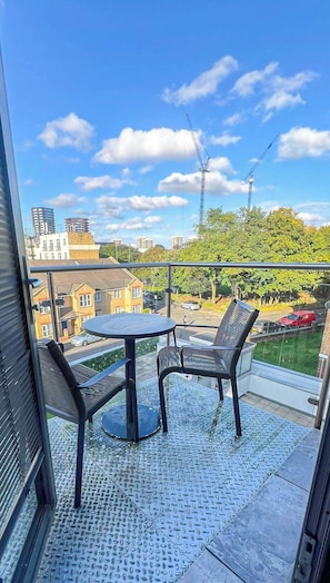 Sunny balcony with a charming seating area, providing a relaxing spot to enjoy panoramic views of Shoreditch and its vibrant surroundings.