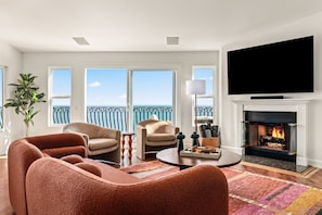 Bright and spacious living room with ocean views, flat screen TV and fireplace