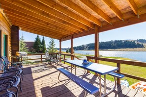 Relax on the expansive back deck of Henry's Hatch Cabin, offering panoramic views of Henry's Lake. Whether sipping coffee or sharing meals, immerse yourself in the tranquility of lakeside living.