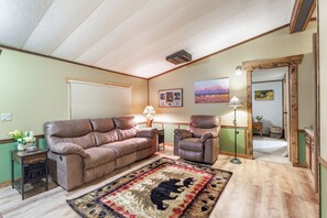 Kick back on plush recliners after a day of exploring, surrounded by rustic touches, warm lighting, and a bear rug that adds a touch of wild Montana spirit.