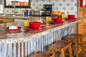 Gather around the chic bar top in Red Rock Lakeview's kitchen for stylish dining. Perfect for casual meals or mingling with loved ones, it's the ideal spot to savor delicious food and create lasting memories in style.
