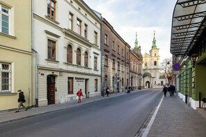 Exterior street view of a historic, urban setting. The architecture is classic, with several multi-story buildings lining the street.