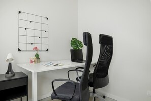 A dedicated workspace with a white desk, ergonomic office chair, and decorative elements, perfect for remote work or study.

