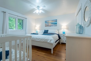 Spacious king bedroom with additional crib for a baby.