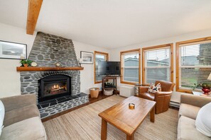 Living room with Electric fireplace, Smart TV, comfy furniture, Open to the dining room and fully equipped kitchen.