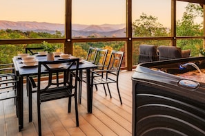 Upstairs deck with hot tub, dining space, comfortable seating  creates an amazing retreat from which to enjoy panoramic views of the Smoky Mountains.