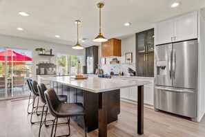 Modern kitchen equipped with high-end appliances and a large island, ideal for breakfast or casual dining.