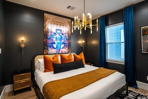 The Retrofuturism Room features a large king bed with design elements calling upon the golden past. The moody bedroom escape features a large 65" Smart TV and high end comfortable mattress