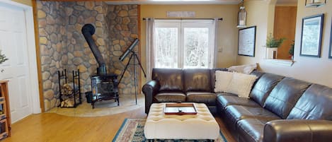 Gorgeous living room with leather couch and cozy wood burning stove