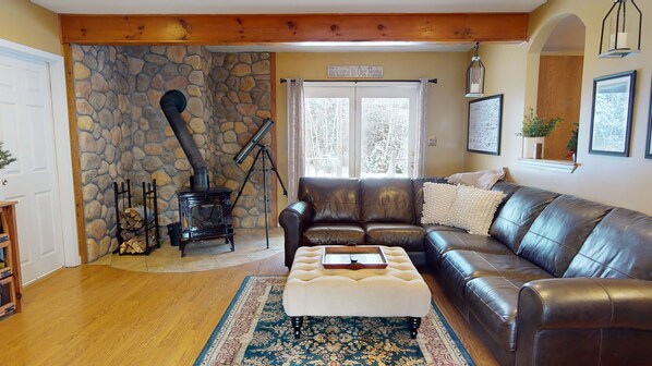 Gorgeous living room with leather couch and cozy wood burning stove