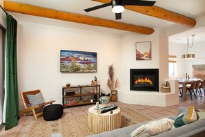 Living room with wood beams, gas fireplace, smart TV, and seating for the whole family