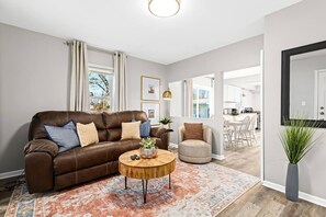 Indulge in comfort and style in this inviting living room, complete with a cozy sofa. Sink into the plush cushions and unwind while watching your favorite shows on the sleek TV, making this space the ideal retreat for relaxation and entertainment.
