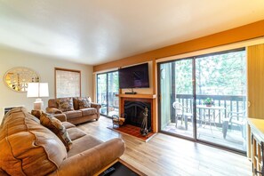 Living room has large flatscreen TV and wood burning fireplace. Two private decks overlooking the pine tree forest.