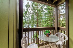 Private deck with quaint seating area nestled in the trees.