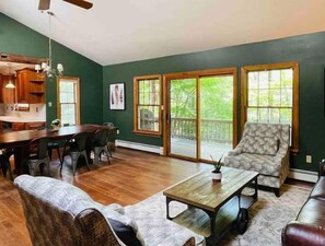 Living room and dining room. Sliding doors open to deck with a river view.