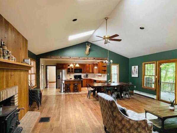 Living room, dining room, and kitchen. Door to master bedroom is pictured.