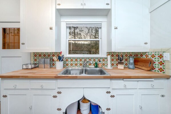 View of kitchen sink and plenty of cabinets for storage
