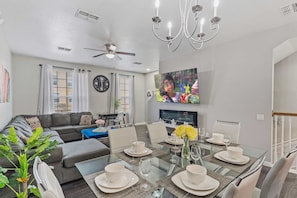 Dining area and living room with indoor fireplace and large smart TV