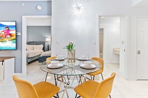 Living room with large smart TV, sleeper sofa and kitchen