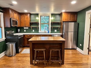 Fully stocked kitchen with new stainless steel appliances and breakfast bar.