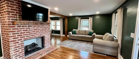 Open floor plan with kitchen, living and dining connected. TV extends from wall.