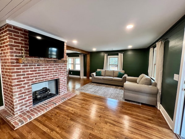 Open floor plan with kitchen, living and dining connected. TV extends from wall.