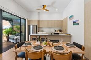 The open-plan dining and kitchen area opens straight to the deck, creating a seamless transition between indoors and out.
