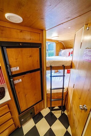 DARLING DAISY RV 1Twin bunk beds tucked in the corner of the RV allow for guests to sleep comfortably after a day of exploring San Diego. The removal step ladder allows easy access up and down from the top bunk.