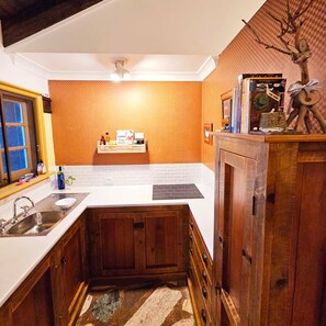 Kitchen with an electric cooktop, all the cutlery, utensils and pots and pans.