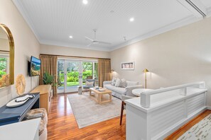 Elegant living space with natural light, modern décor, and garden views.